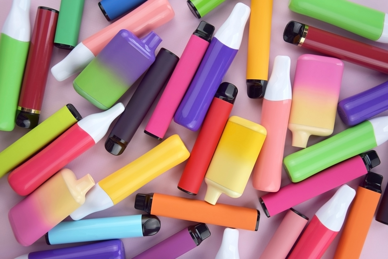 Ein Haufen verschiedener, bunter, gebrauchter E-Zigaretten und Vapes