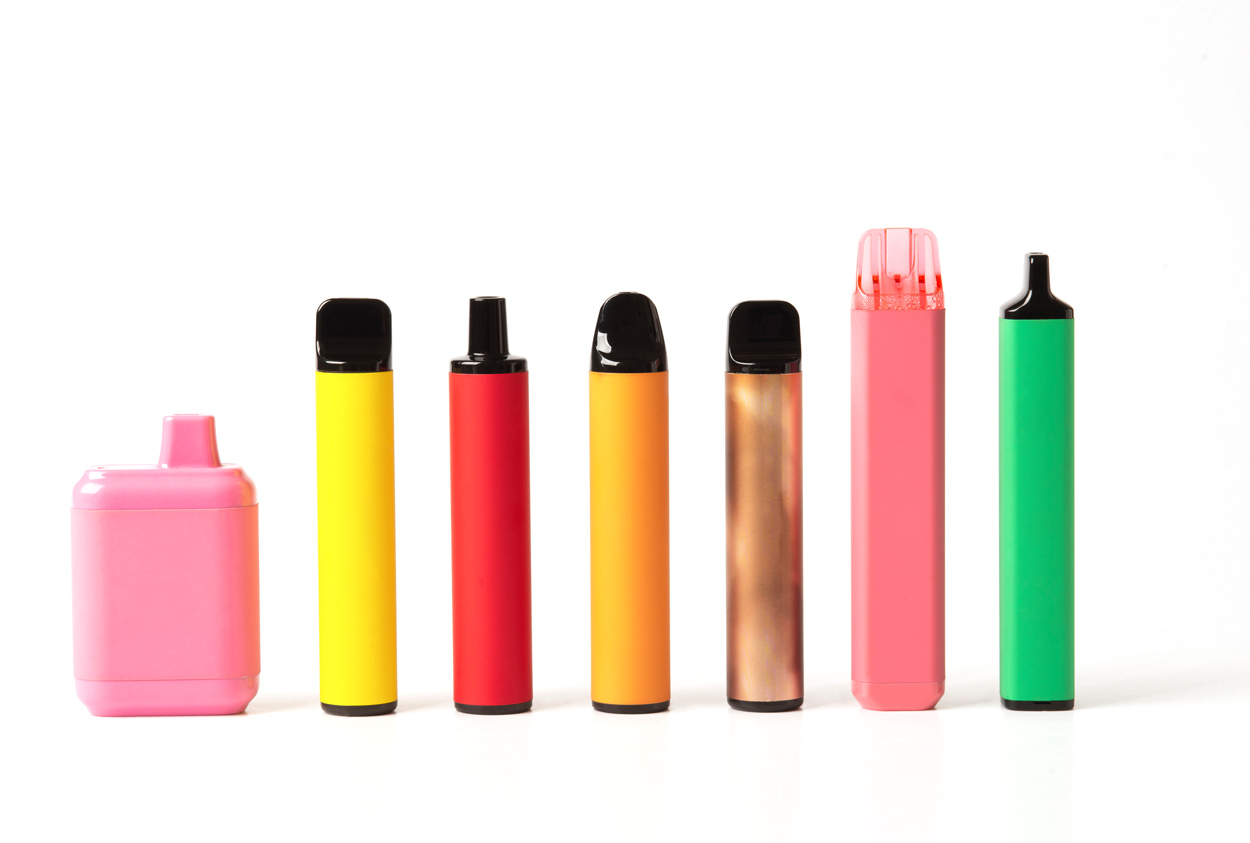 Eine Reihe von verschiedenen, farbigen Vapes und E-Zigaretten mit wei&szlig;en Hintergrund