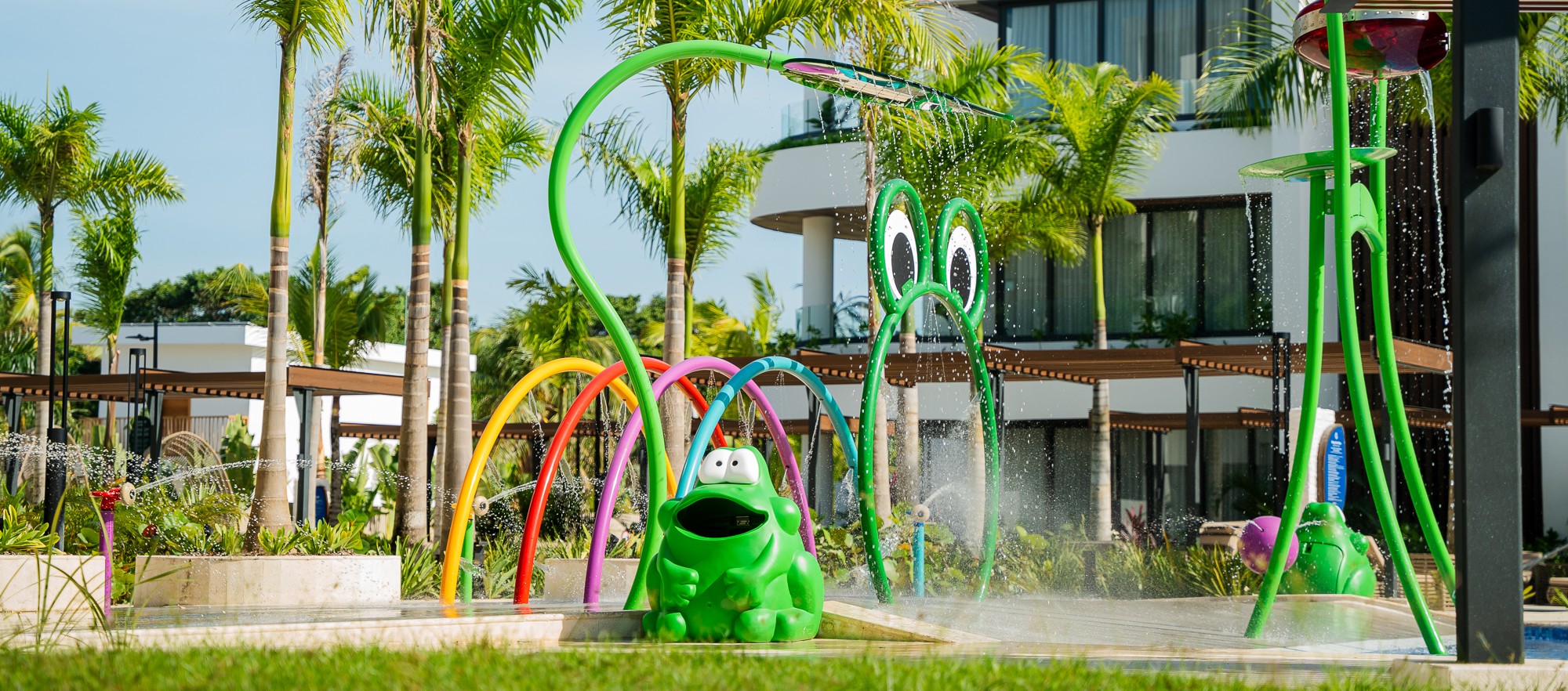 wide shot of a Glasdon frog-shaped Froggo litter bin and the playground behind it in Donoma Las Terrenas Beach Resort and Spa in the Dominican Republic