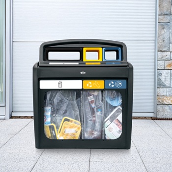 Una estaci&oacute;n de reciclaje de recogida selectiva con tres compartimentos para diferentes tipos de residuos, ubicada en un espacio p&uacute;blico y con paneles transparentes que permiten ver f&aacute;cilmente el contenido de los contenedores.
