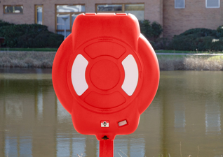 Coffre à bouée Guardian™ en rouge à l’extérieur avec bouée de sauvetage dehors terrains de l’hôtel