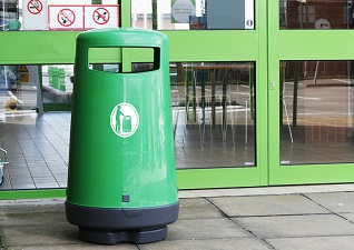 Poubelle d’extérieur Topsy™ 2000 vert à l’extérieur d’un supermarché