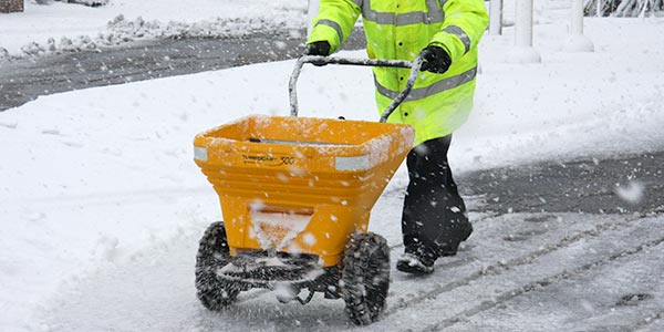 Épandeur à sel manuel Croisière™ 300 en fonctionnement dans la neige