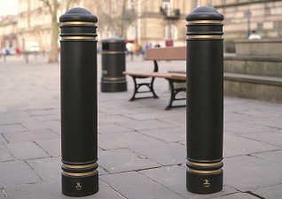 Jubilee™ Bollards in black with gold banding in city centre in front of traditional seating and litter bin