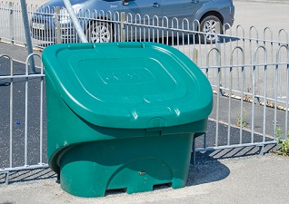 Nestor™ 400 Lockable Grit Bin in green located outside a housing block