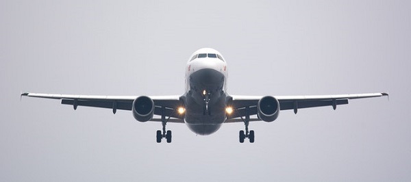 A plane flying through the air as it comes in to land