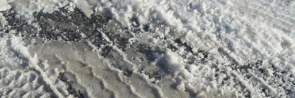 Road Ice melting with a tyre track through it