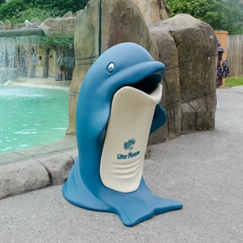 A large bin shaped like a dolphin in a zoo next to an aquatic animal&rsquo;s habitat