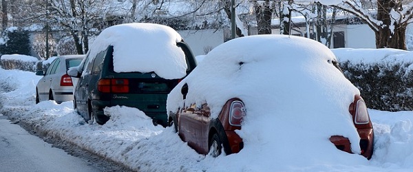 Three cars parked on the road in snowy conditions