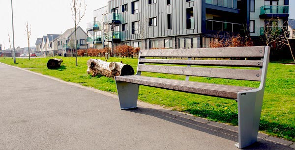 Vistra parkbank bevestigd naast een grasberm in een modern architectonisch gebied