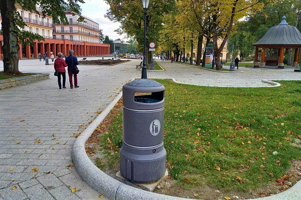 Kosz na śmieci Mini Plaza na betonowej podstawie na trawie