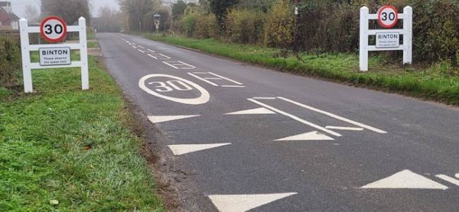 Image of two vilage gateway signs with speed limit sign.