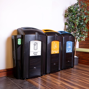 three black nexus 100 recycling bins in a modern setting with different waste streams