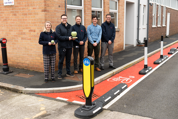 members of the product design team holding the green apple award stood next to endurokerb cycle lane defenders outdoors