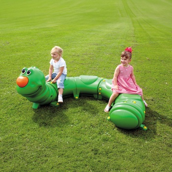 A green caterpillar shaped Glasdon bench with an orange nose and googly eyes on a green field with two children sitting on it