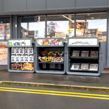 Glasdon Nova storage units outside of a shop displaying a variety of products within them