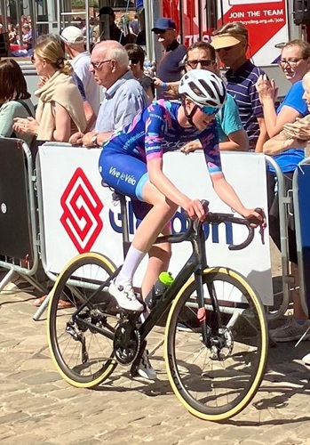 cyclist riding past a crowd in the lincoln grand prix with a barrier with a glasdon logo in the background