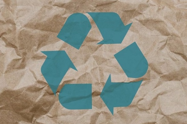 Green recycling logo on a piece of scrunched brown paper