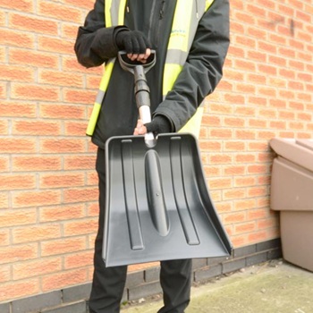 A person in a hi-viz jacket getting ready to use the Glasdn Snospade snow shovel to shovel snow in winter.