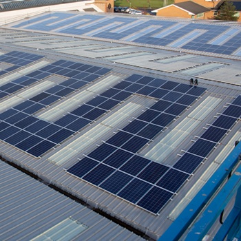 Solar panels installed on the roof of a factory or warehouse on a sunny day