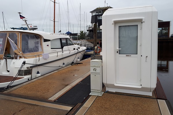 A Genesis Kiosk beside a boat on a harbour