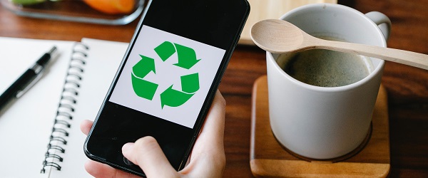 A mobile phone showing a recycling logo on the screen