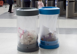 C-Thru™ 50G Transparent Trash Cans for plastic film recycling and regular trash inside transport facility